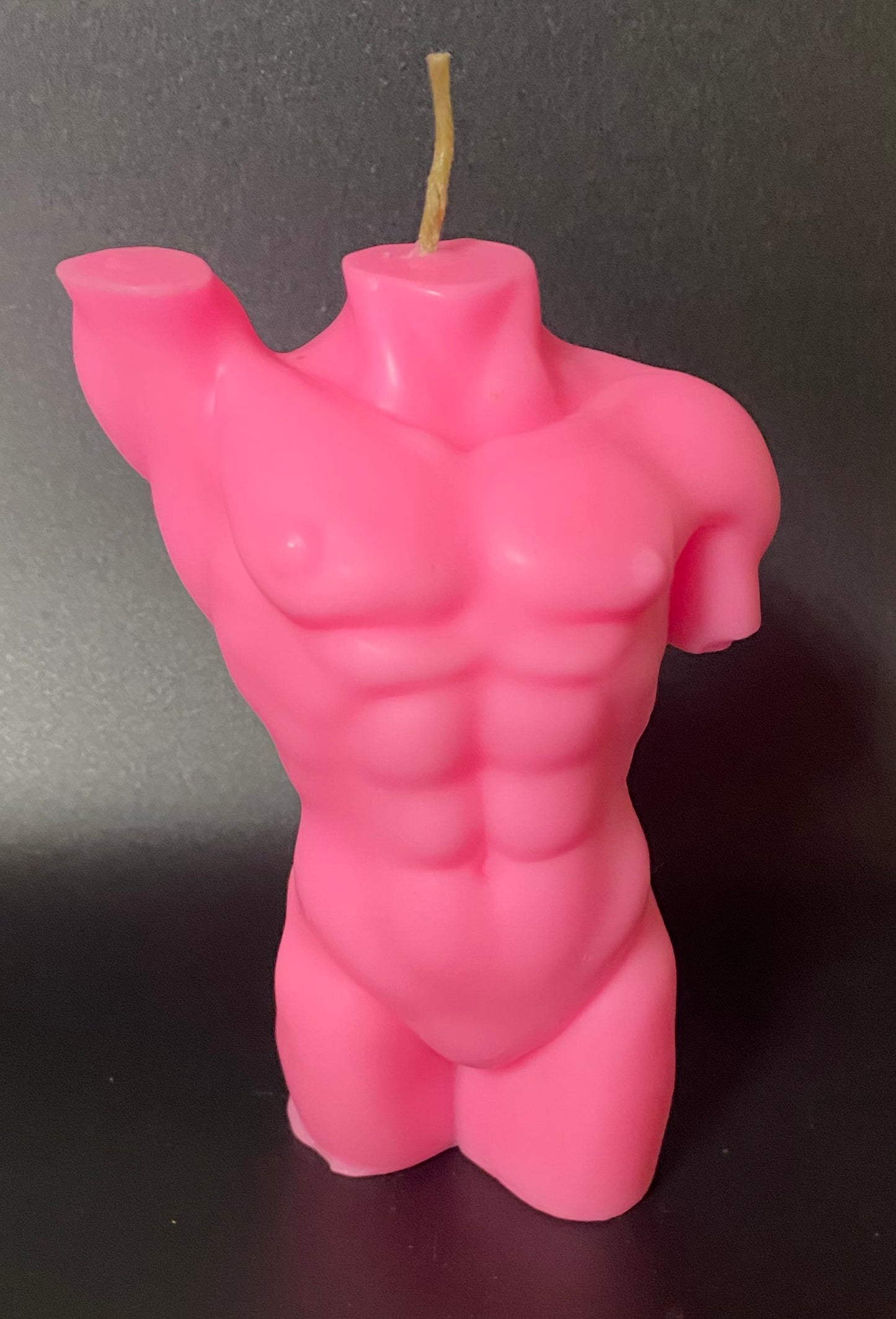 Pink bodybuilding man candle on a black background