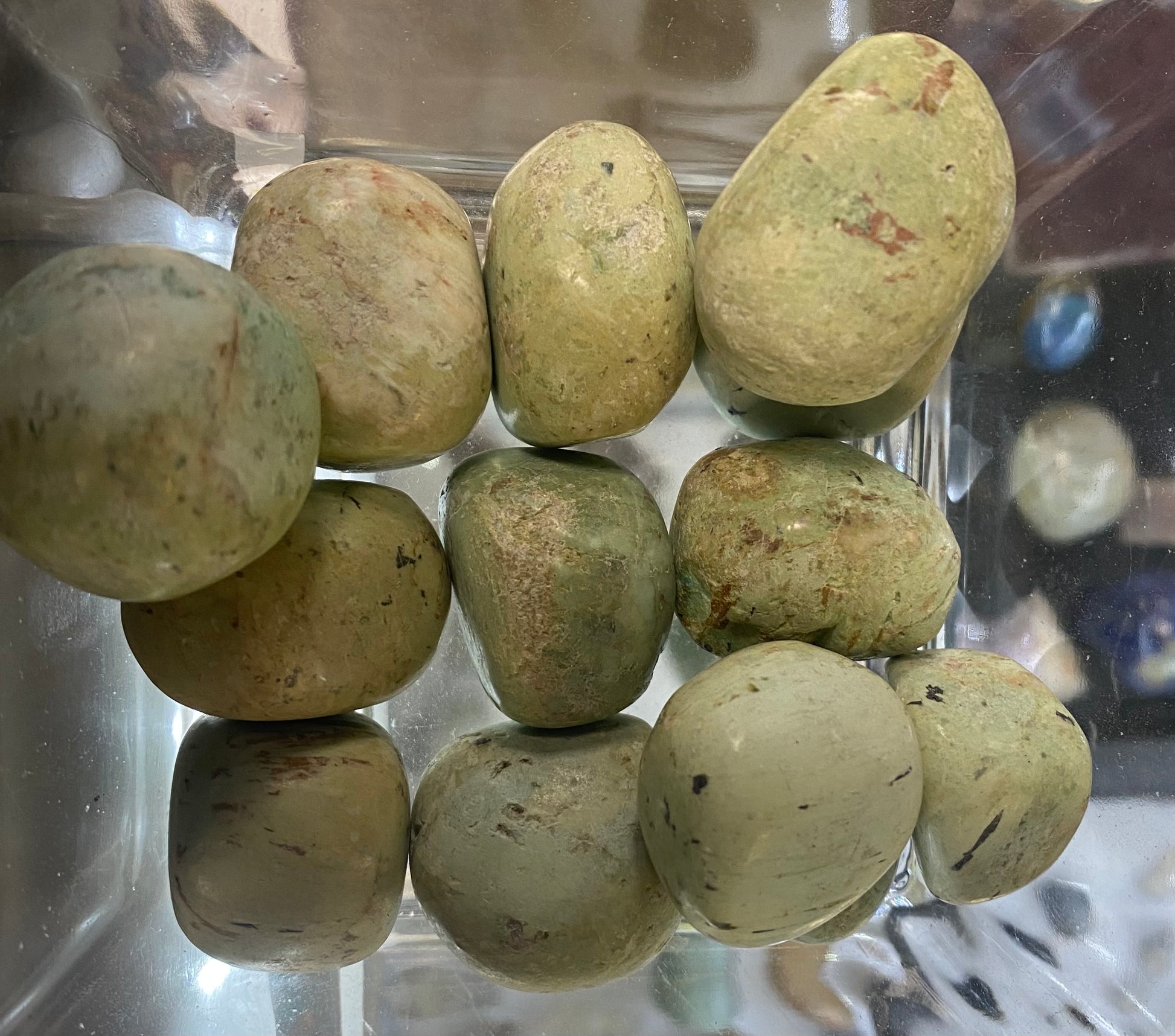 Greenish stones in a clear plastic container