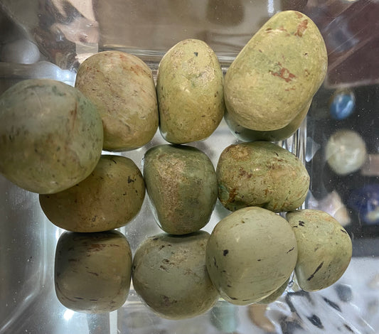 Greenish stones in a clear plastic container