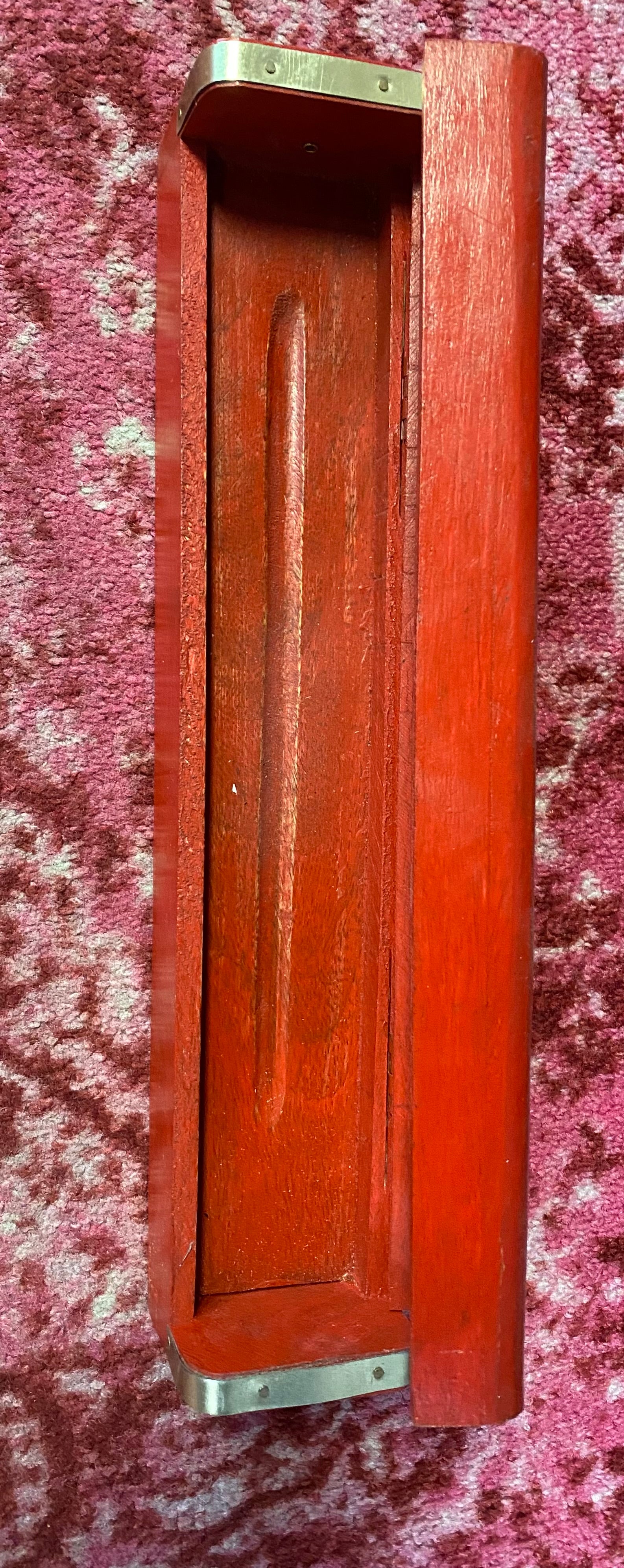 Wooden box with a metal clasp on a textured purple surface