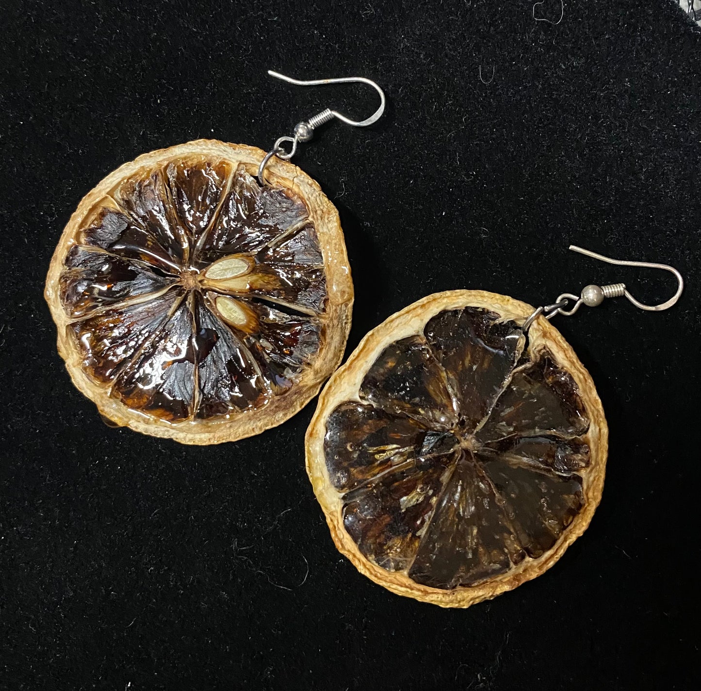 Earrings made from dried lemon slices on a black background