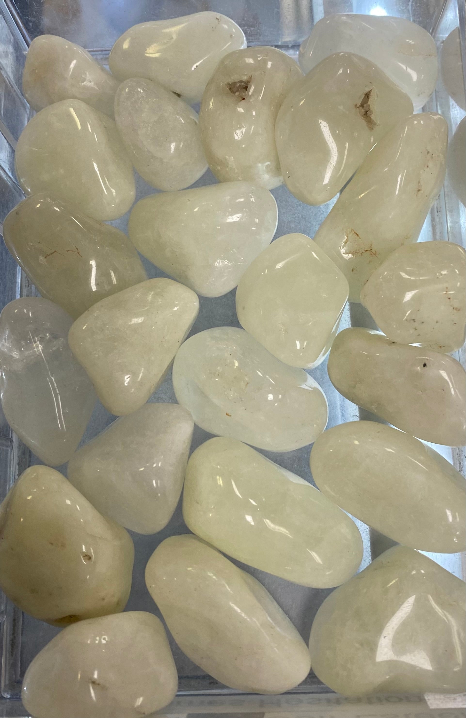 Collection of light-colored stones in a clear container