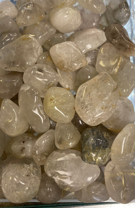 Collection of rough gemstones in a clear container