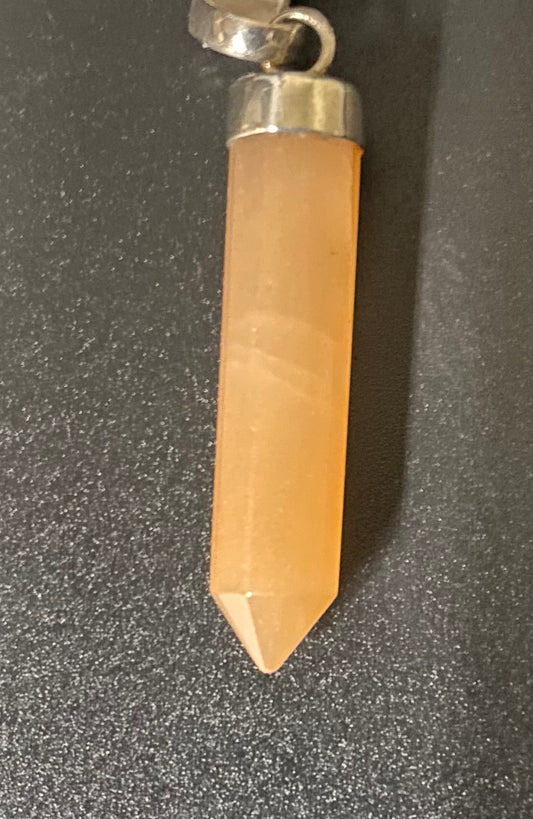 Crystal pendant with silver top on a dark surface