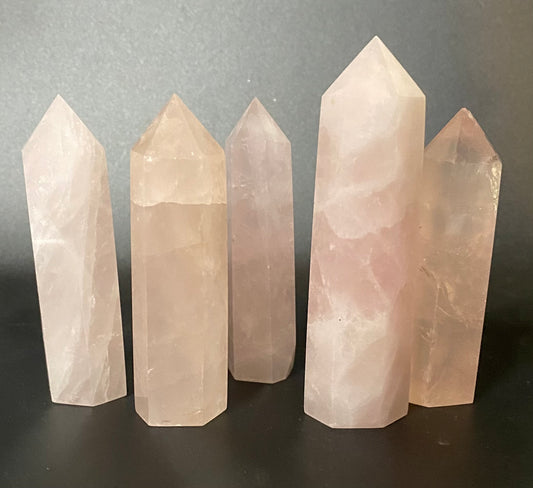 Five crystal towers of varying heights on a dark surface with a gray background