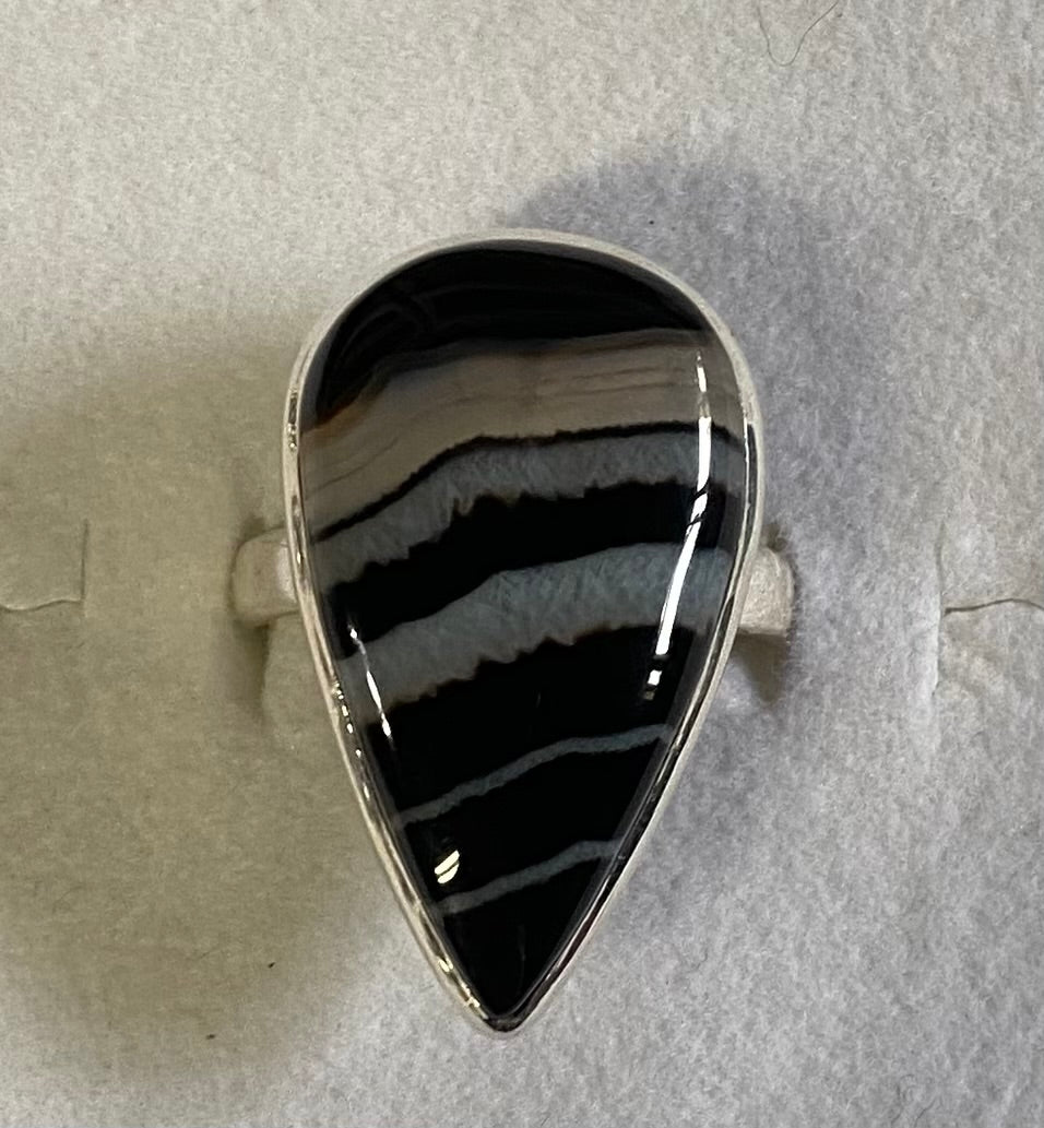 Black and white striped stone in a silver setting on a light gray background
