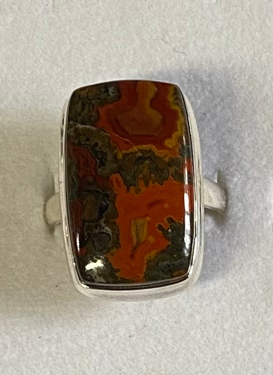 Ring with a large, colorful stone on a light gray background