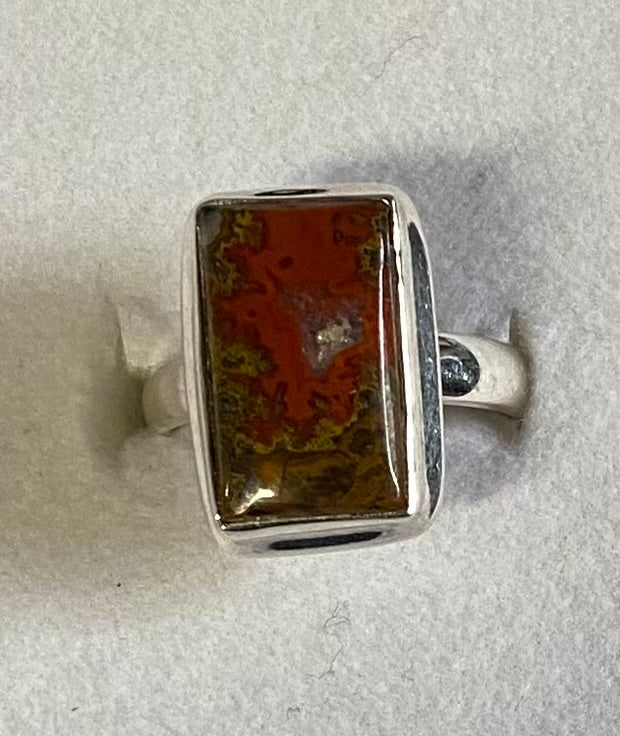 Silver ring with a rectangular stone on a light gray background