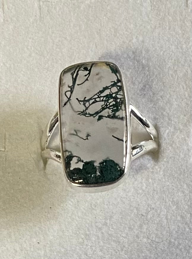 Silver ring with a rectangular stone on a light gray background