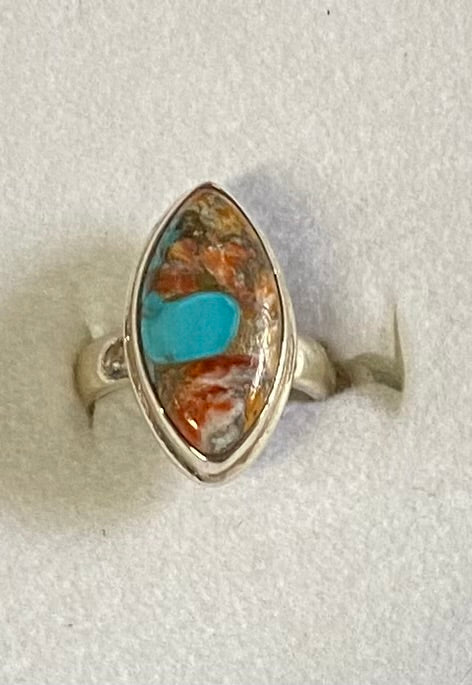 Silver ring with a colorful stone on a white background