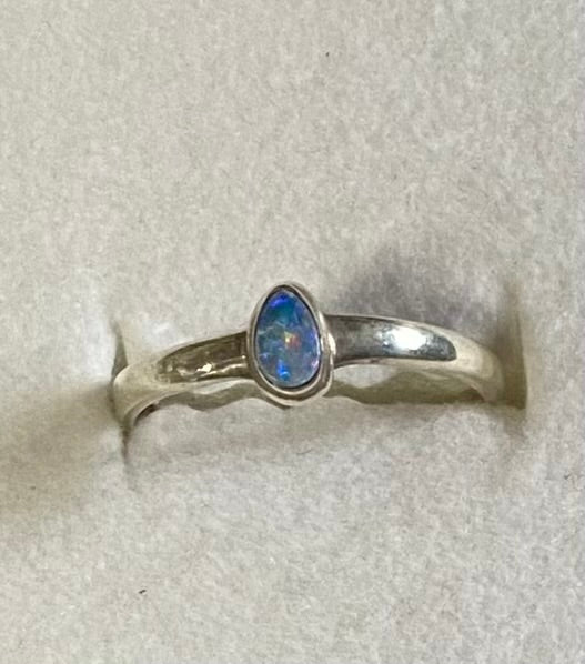 Silver ring with a opal on a light gray background