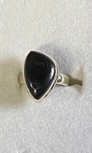 Silver ring with a black stone on a white background