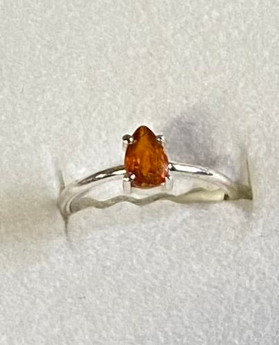 Silver ring with a brown gemstone on a light gray background