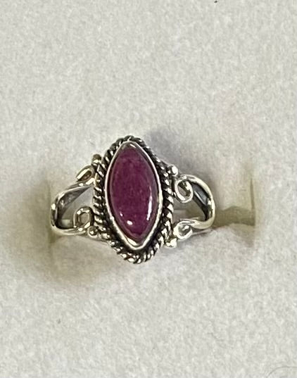 Silver ring with a ruby gemstone on a white background