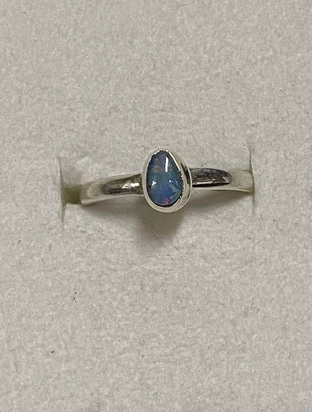 Silver ring with a opal on a light gray background