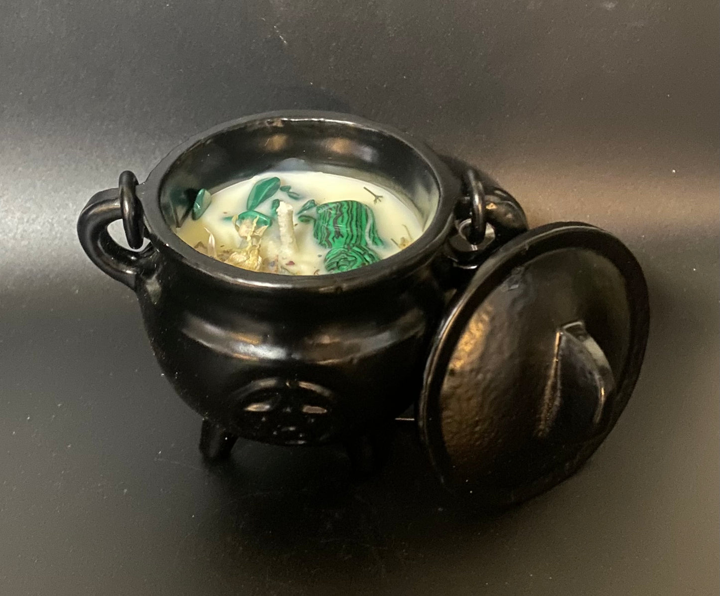 Black cauldron with a lid on a dark background