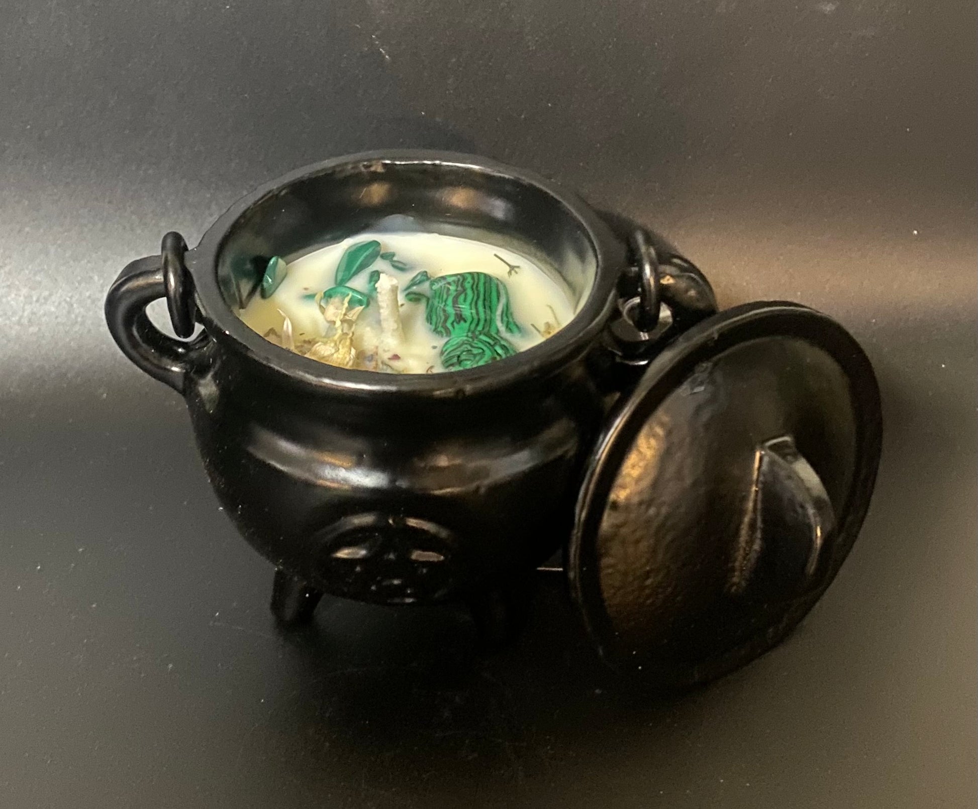 Black cauldron with a lid on a dark background