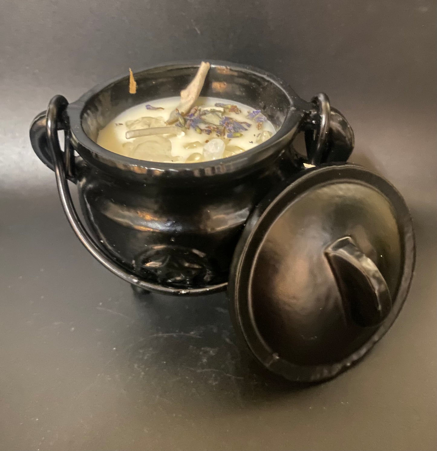 Black cauldron with a lid on a dark surface