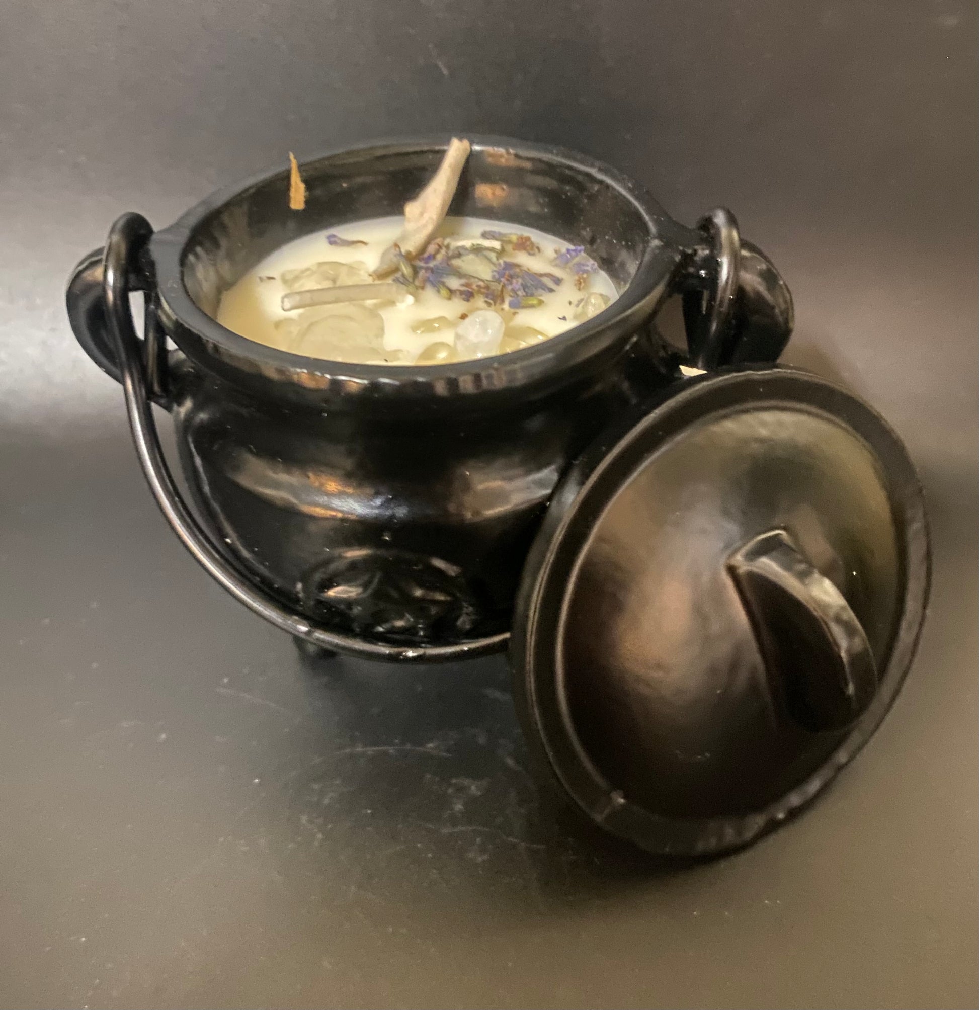 Black cauldron with a lid on a dark surface