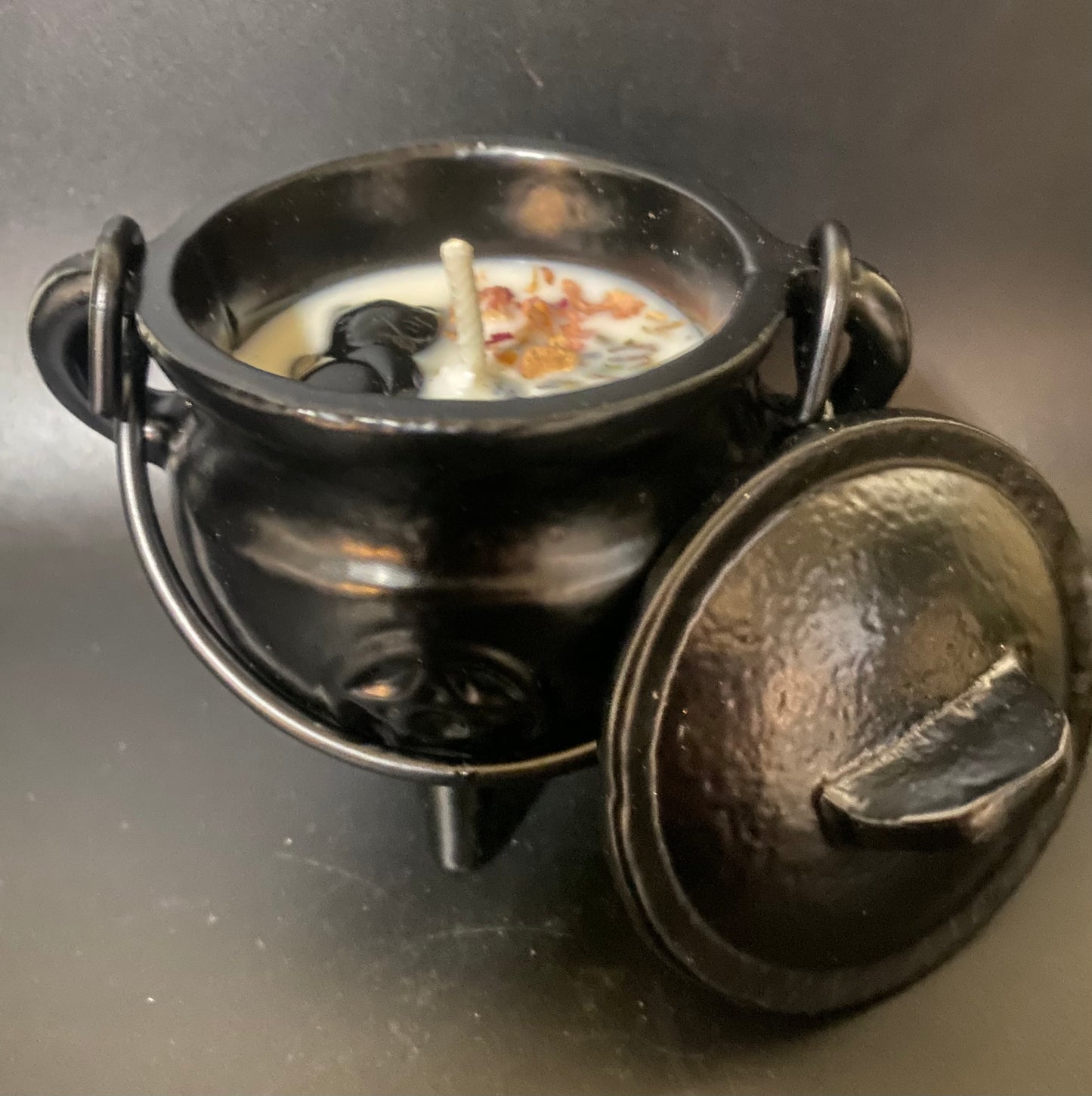 Black metal cauldron with a lid on a dark background