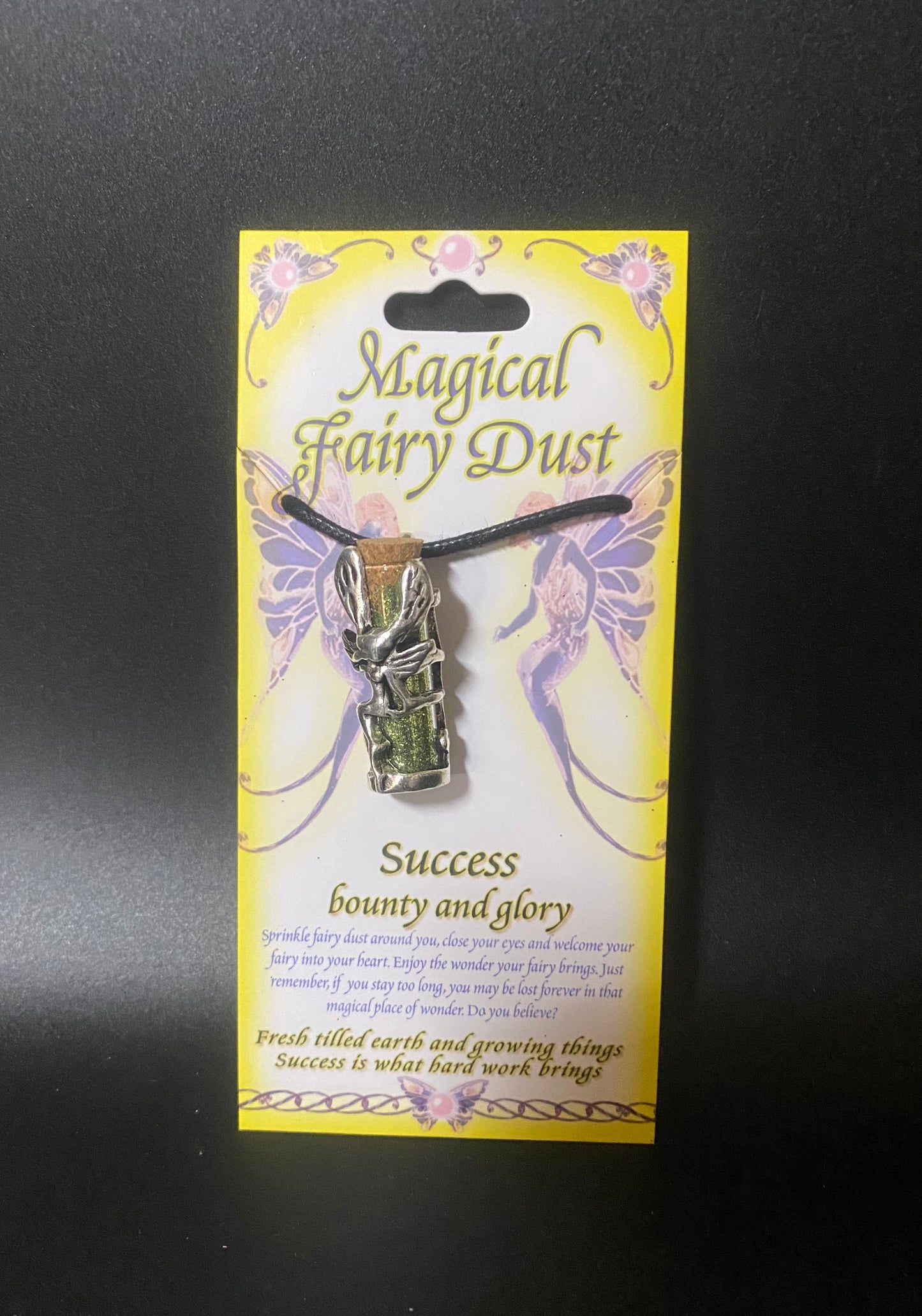 Magical Fairy Dust necklace on a yellow card with text and fairy designs.