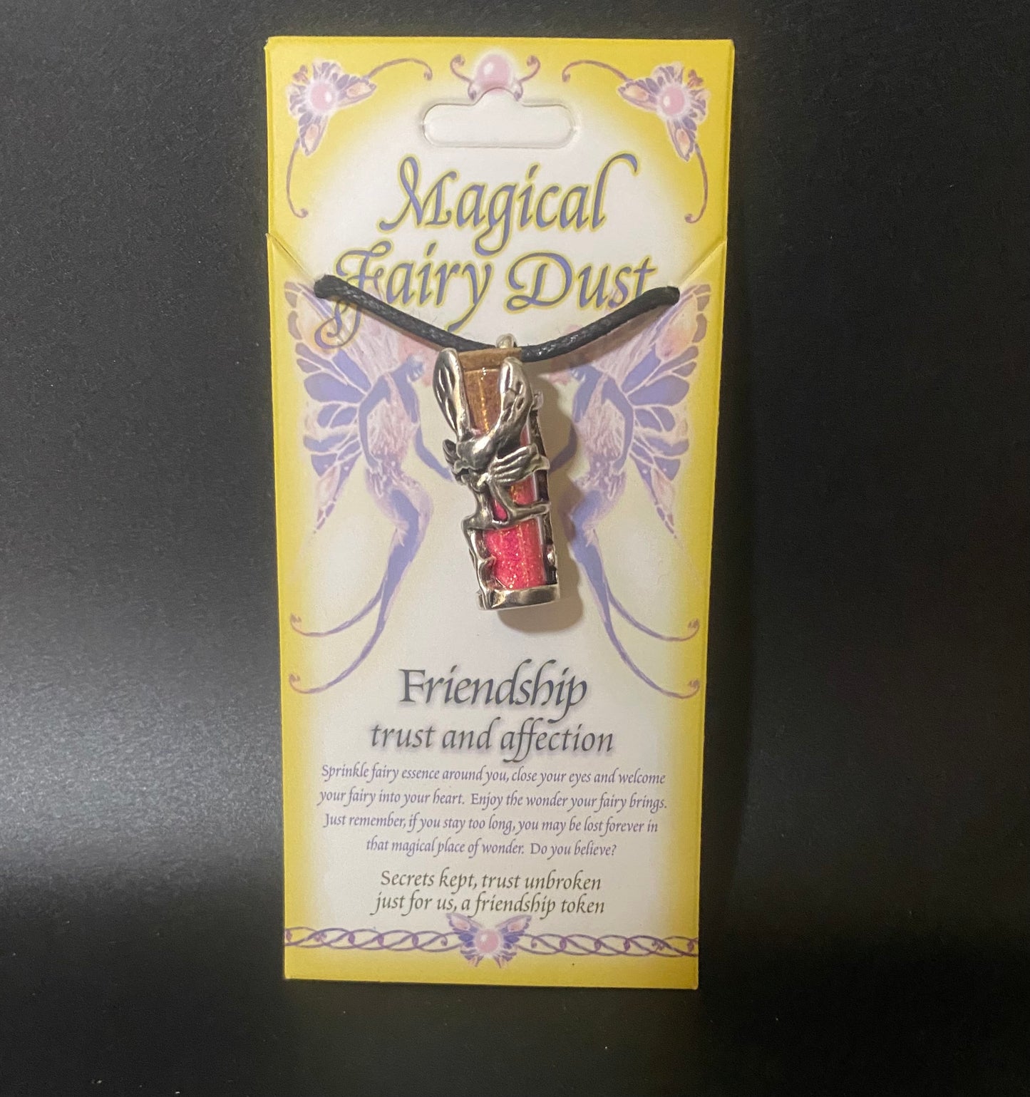 Necklace with fairy dust charm on a decorative card