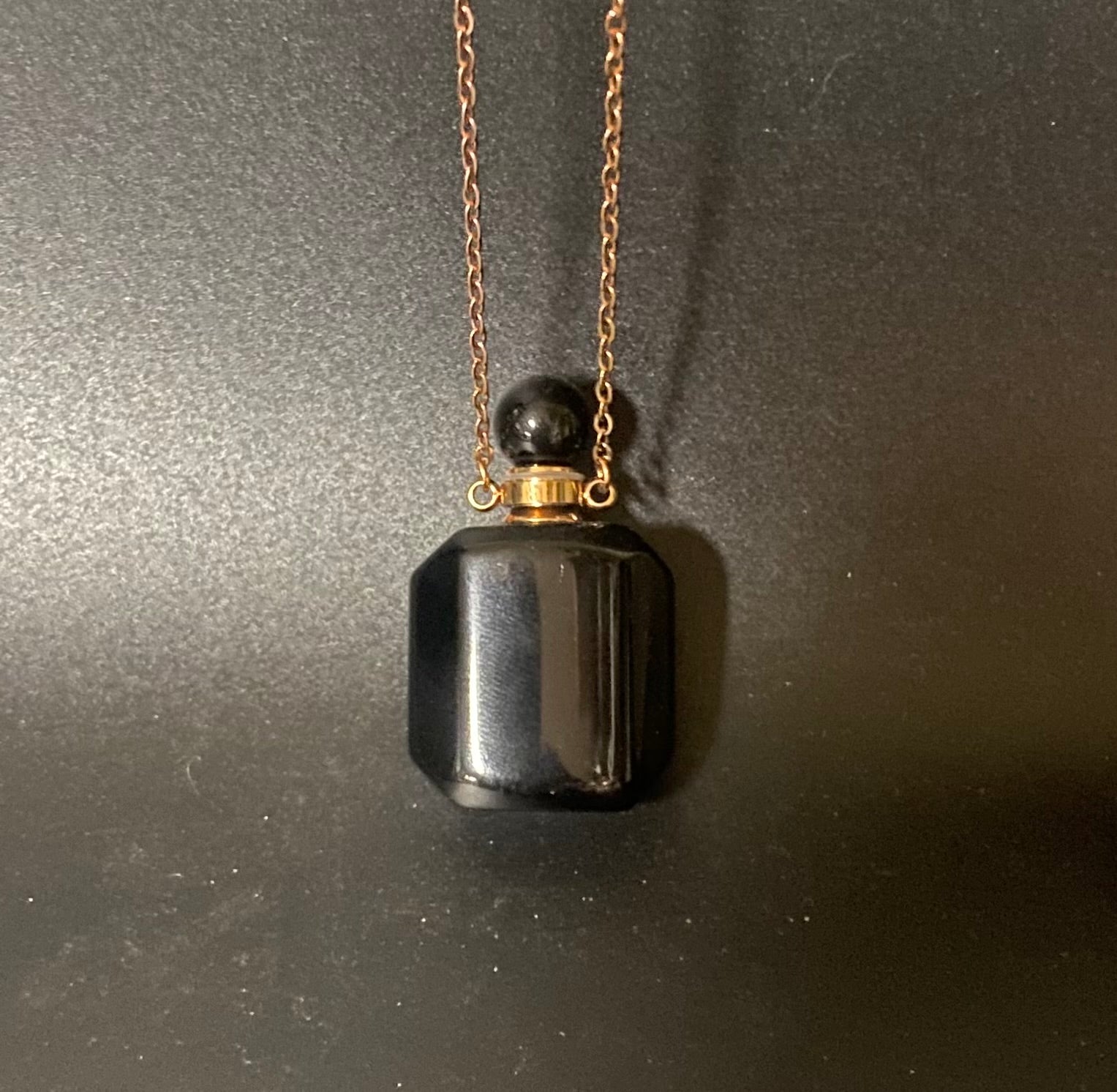 Black pendant necklace on a dark background