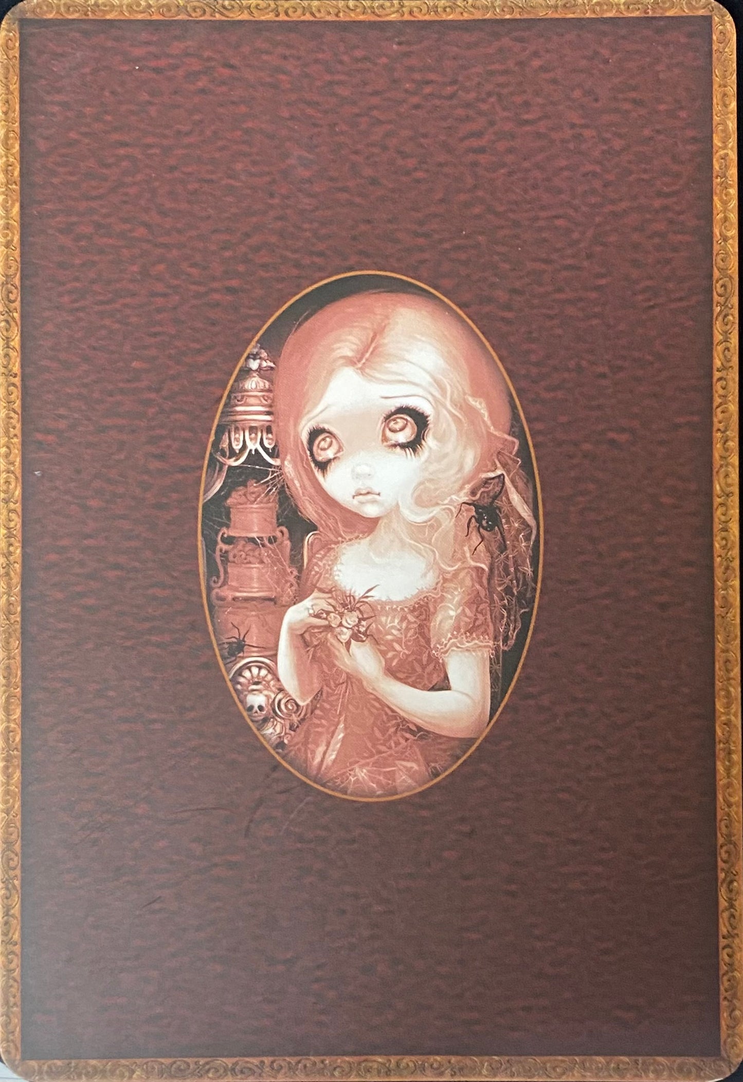 Decorative back of card with an illustration of a girl holding a bird on a brown background