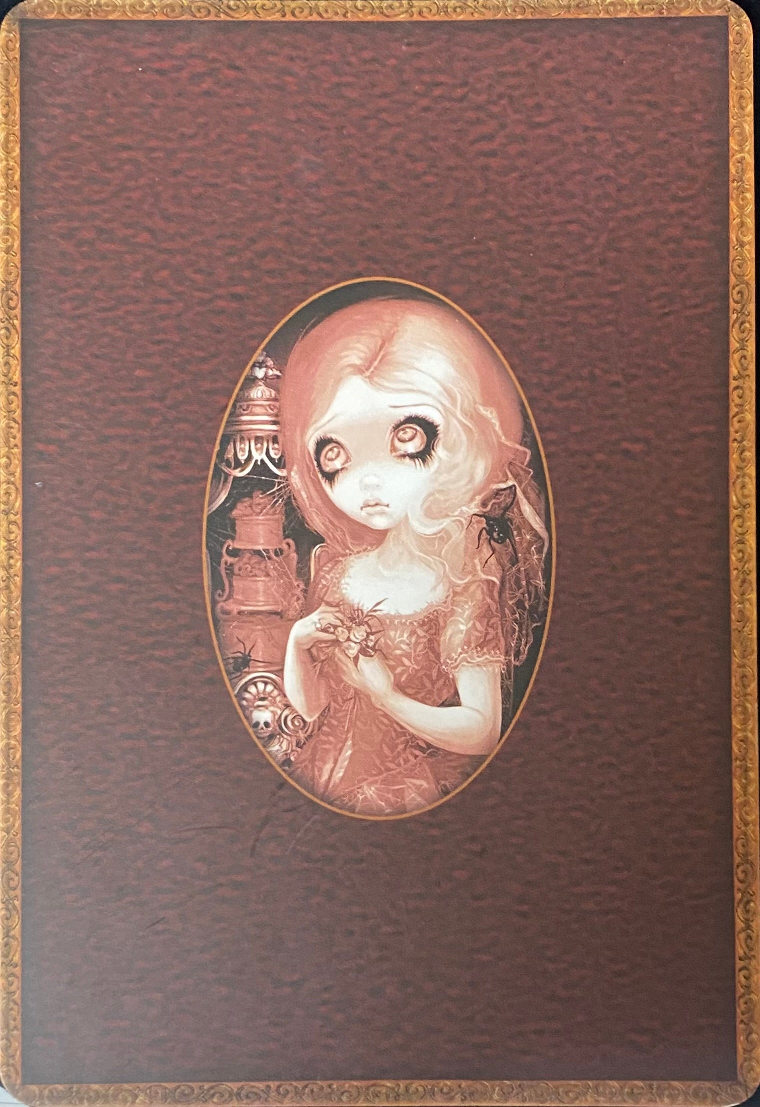 Decorative back of card with an illustration of a girl holding a bird on a brown background