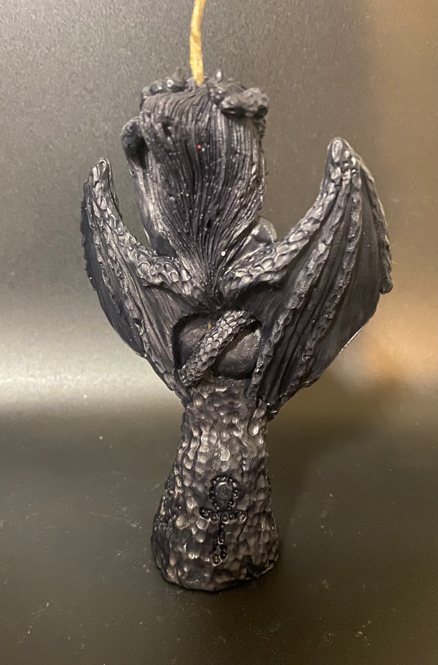 Black dragon-shaped candle on a dark background