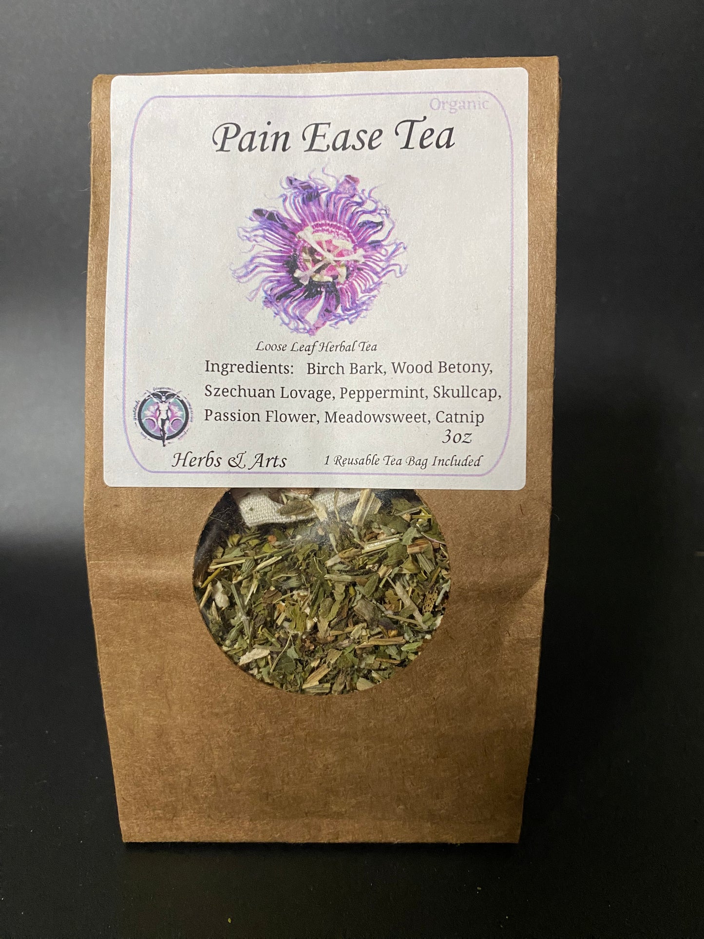 A stand-up kraft paper pouch of Pain Ease Tea with a white label and a circular window showing loose leaf herbal tea inside, photographed against a dark background.