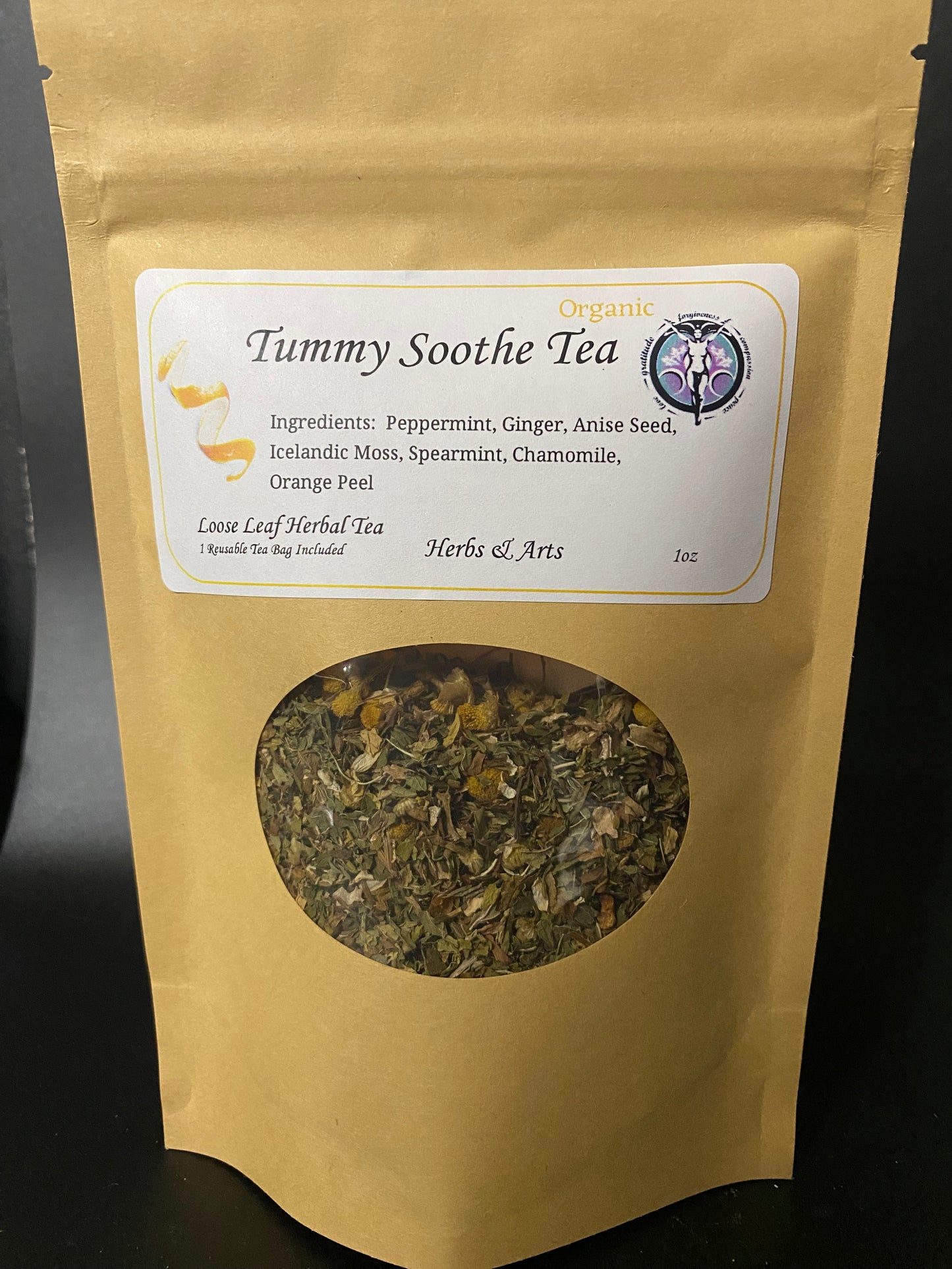 A stand-up kraft paper pouch of Tummy Soothe Organic Loose Leaf Herbal Tea with a circular window showing the dried tea blend inside, photographed against a dark background.