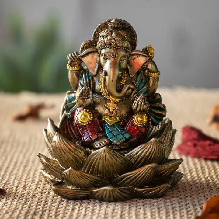 Colorful Ganesha statue on a textured surface with a blurred background