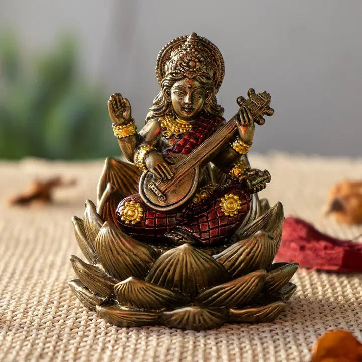 Decorative statue of a seated figure playing a stringed instrument on a lotus base.