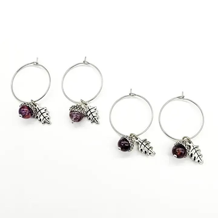 Four earrings with purple berries on a white background