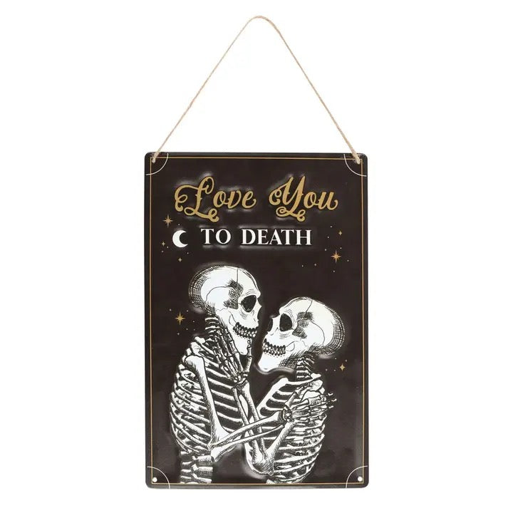 Decorative sign with skeletons embracing and 'Love You To Death' text on a black background.