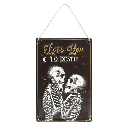 Decorative sign with skeletons embracing and 'Love You To Death' text on a black background.