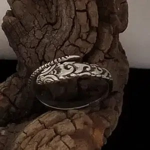 Decorative silver ring on a textured brown surface