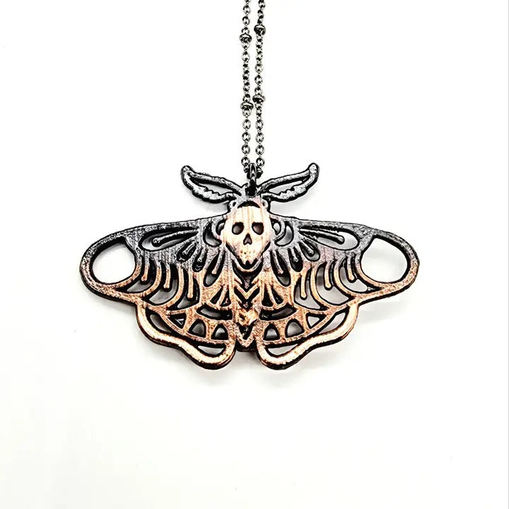Necklace with a detailed moth-shaped pendant on a white background