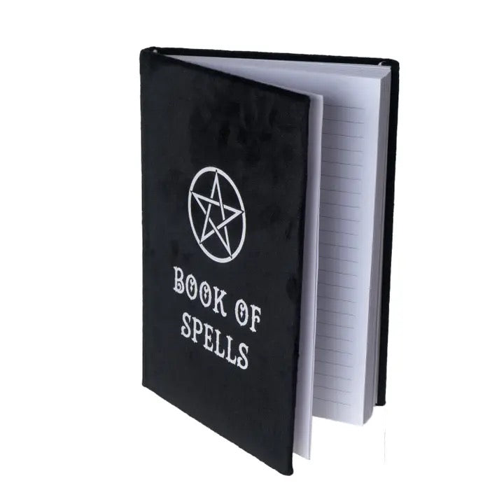 Black notebook with 'Book of Spells' text and pentacle symbol on a white background