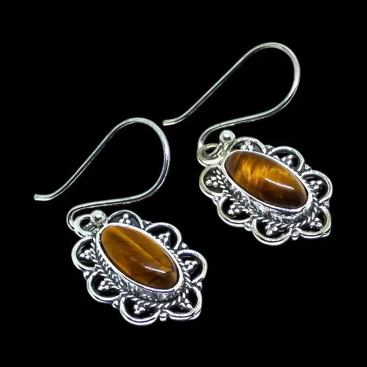 Silver earrings with brown gemstones on a black background