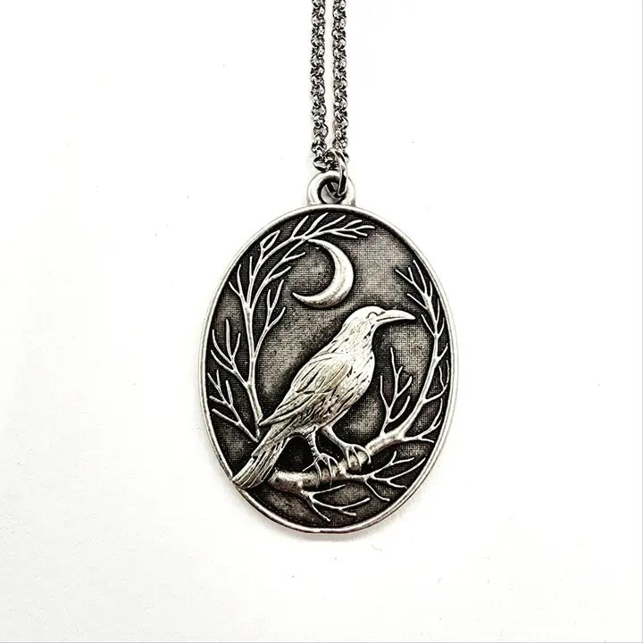Silver pendant with a bird design on a white background