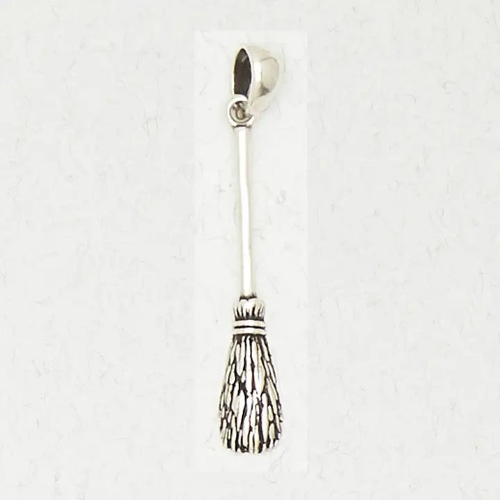 Silver broom charm on a white background