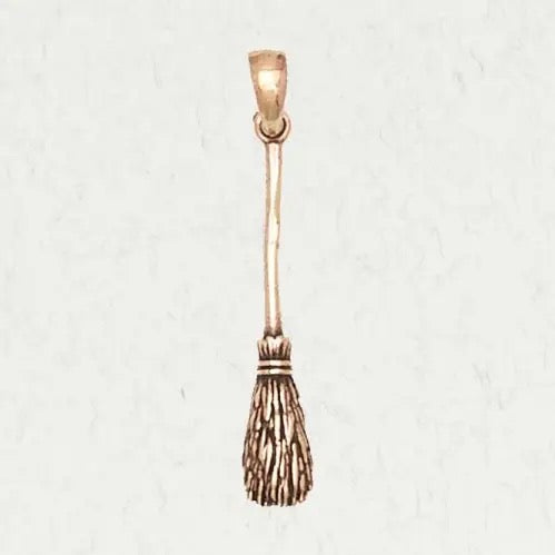 Bronze broom charm on a white background