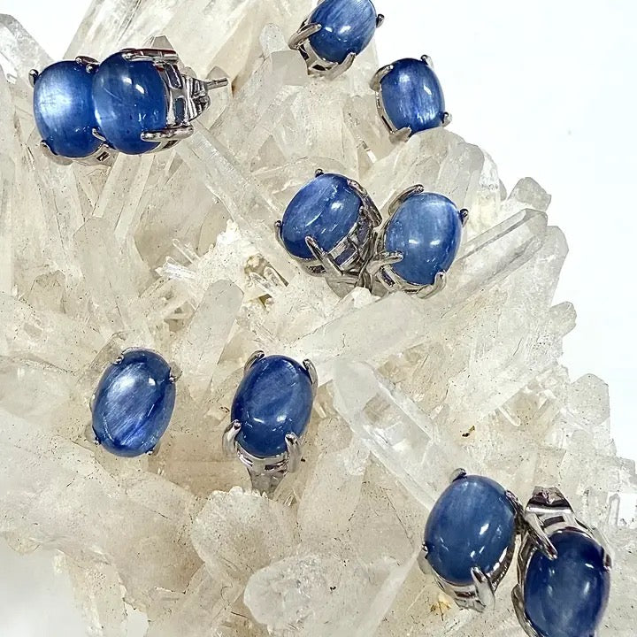 Blue gemstones in silver settings on a crystal background