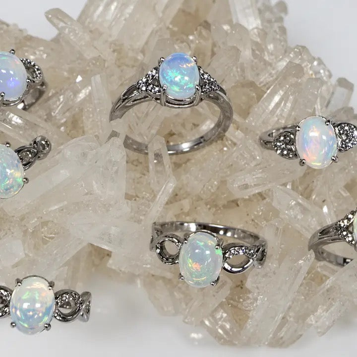 Silver rings with opal stones on a crystal background