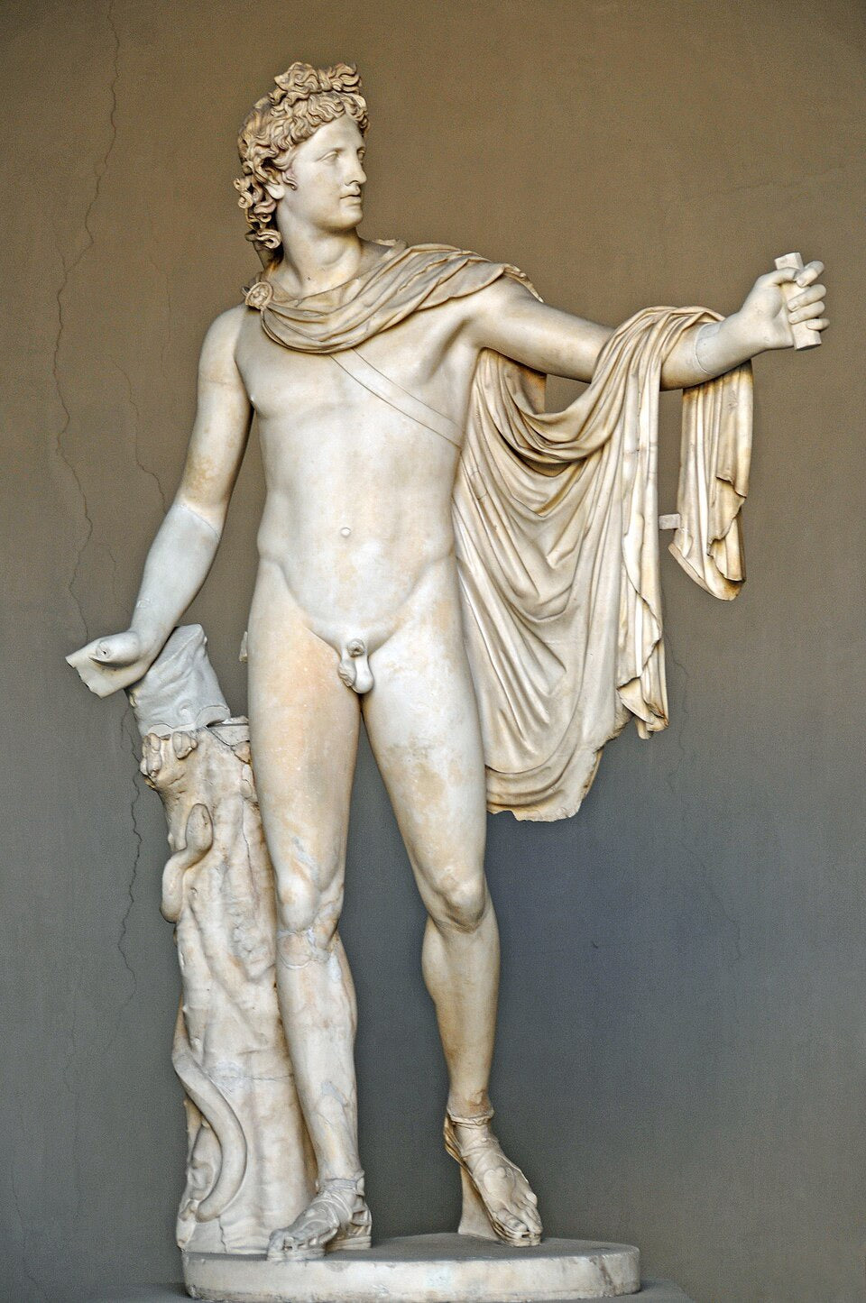 Marble statue of a classical figure with draped garment against a plain background