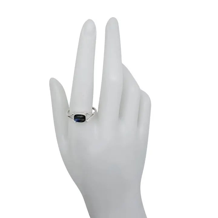 Silver ring with a blue gemstone on a white mannequin hand