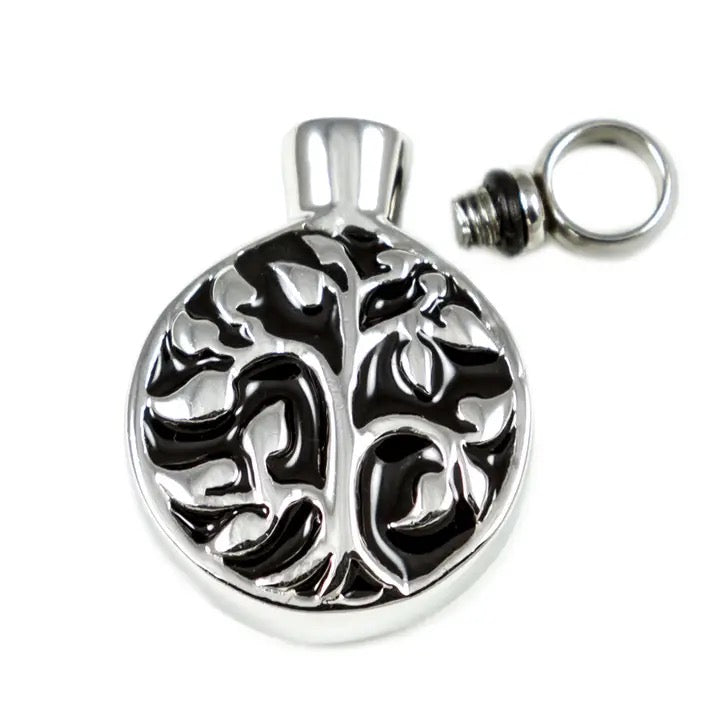 Silver pendant with tree of life design on a white background