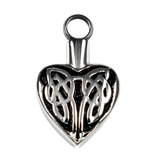 Silver heart-shaped pendant with intricate design on a white background